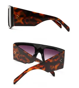 Detail of tortoise shell sunglasses with wide temples and silver triple stud accents