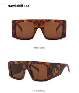 Close-up of tortoise shell oversized square sunglasses with signature silver dots