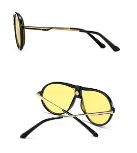 Detail of pilot sunglasses with yellow lenses, gold temples and leather bridge accent