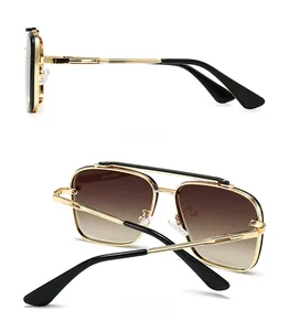 Detail view of gold metal aviator sunglasses with brown gradient lenses and dual bridge