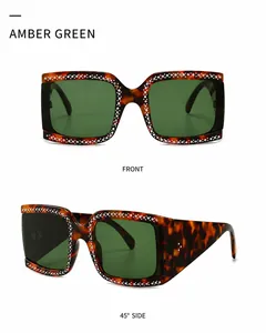 Detailweergave van de oversized vierkante amber zonnebril met strass en groene glazen