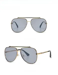Detail view of gold aviator sunglasses with gray lenses and double bridge design