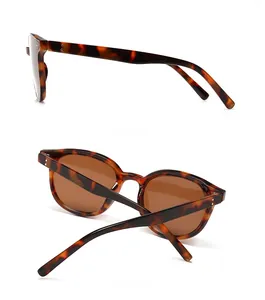 Detail view of tortoiseshell sunglasses frames with brown lenses and metal rivet accents