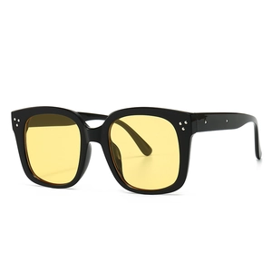 Modern vintage square sunglasses with thick black frames and yellow amber lenses