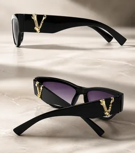 Detail einer Vintage-Sonnenbrille mit goldenem V-Metalllogo und lila Verlaufsgläsern