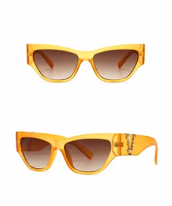 Orangefarbene Cat-Eye-Sonnenbrille mit goldener Metallkette am Bügel und Verlaufsgläsern
