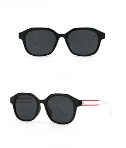 Detailansicht der schwarzen Oversize-Sonnenbrille mit transparenten rot geteilten Bügeln