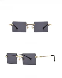 Close-up of black square rimless sunglasses with gold metal frame and stepped lens edge