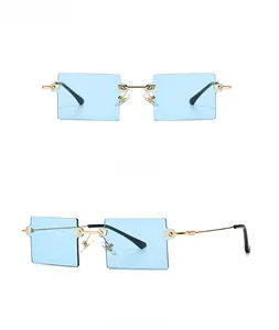 Detail view of square rimless sunglasses with light blue lenses and gold metal frames