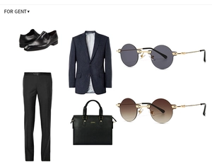 Flat lay of men's black derby shoes, navy pinstripe suit, and leather briefcase set