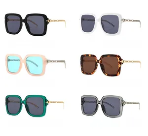 Detail view of square oversized sunglasses with gold metal chain braided temples