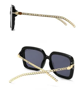 Detail of square oversized sunglasses with unique gold chain-link temple design