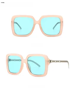 Detail view of square frame sunglasses with metal chain temples and light blue lenses