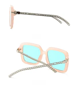 Detail view of retro square sunglasses with silver chain temples and pink frames