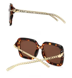 Detail of square oversized tortoiseshell sunglasses with gold metal chain temple design
