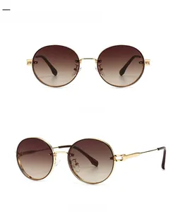 Detailansicht der ovalen Sonnenbrille mit goldenen Metallbügeln und braunen Gläsern