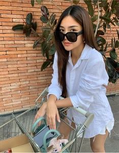 Detail of trendy black oversized sunglasses with a signature logo on wide temples in street style