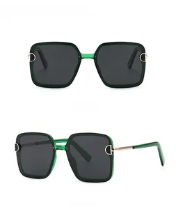 Close-up of square green translucent frame sunglasses with metal D decoration