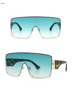 Detail view showing gold metal frame with gradient green lenses and tortoise temples