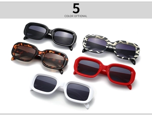 Flat lay of five narrow rectangular sunglasses in black, tortoise, zebra, red, and white