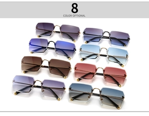 Flat lay of eight multi-color rimless geometric sunglasses with gradient lenses