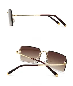 Detail view of rectangular gradient brown lenses and slim golden metal temples of sunglasses