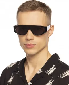 Male model wearing black round shield sunglasses with silver triangle logo on temple
