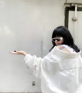 Street style shot of white vintage oval sunglasses with thick frames and black lenses