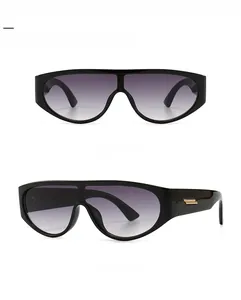 Detail view of black oversized sunglasses with gold metal bars on the temples
