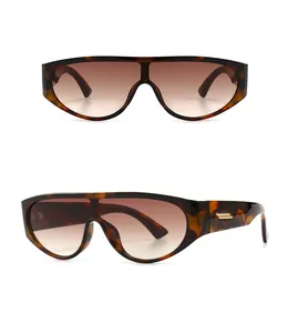 Detail view of leopard print shield sunglasses featuring gold metal hardware on temples