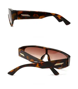 Detail view of tortoiseshell sunglasses with golden metal hinges and gradient brown lenses