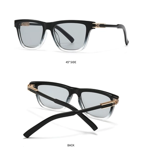 Detail view of butterfly sunglasses with black-white gradient frame and golden metal hinge
