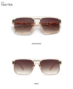 Close-up of tea-colored pilot sunglasses with gradient lenses and a golden double bridge