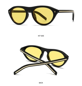 Détail de lunettes de soleil vintage avec monture noire et verres jaunes sous un angle de 45 deg