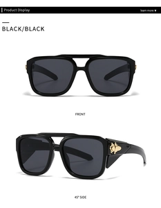 Detail of wide rectangle sunglasses with golden metal hinges and smoke gray lenses