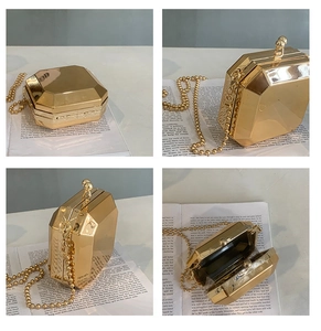 Detail view of a gold octagonal evening clutch bag with metal facets and a beaded chain