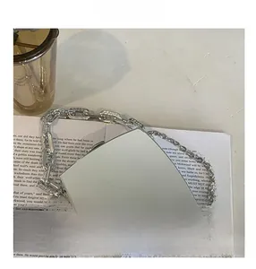 Detailed close-up of a silver mirror acrylic box bag with chunky metallic chain straps