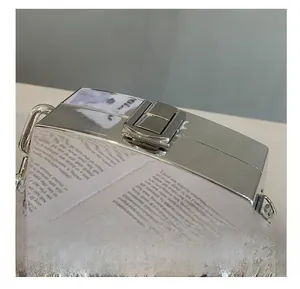 Detailed close-up of the silver mirror clutch metal lock and chain strap design