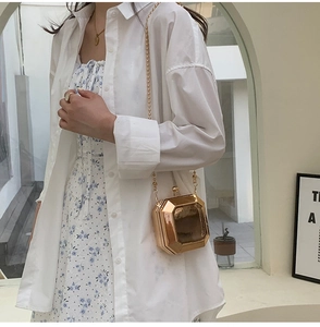 Detailed view of the gold geometric hard shell chain bag paired with a summer outfit