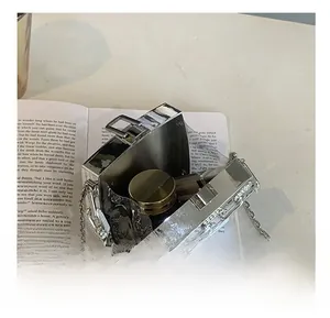 Detailed interior of acrylic box bag showing space for a golden makeup compact