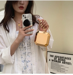 Macro shot of gold octagonal evening bag featuring mirror finish and bead chain strap