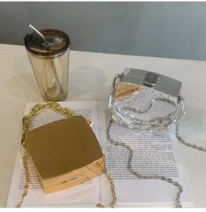 Close-up of gold and silver acrylic mini bags with mirror finish and chunky metal handles