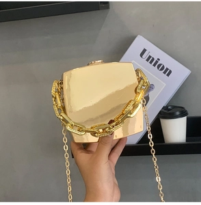 Detail of gold mirror square clutch box bag with thick chain handle and metal strap