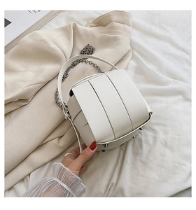Detail of white PU leather box bag featuring woven texture and silver metal chain