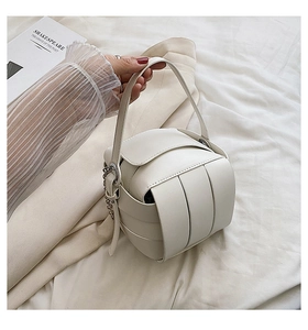 Detail of white woven PU leather handbag with wide interlaced straps and silver chain