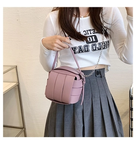 Pink woven PU leather box bag with silver chain strap shown as a crossbody fashion accessory