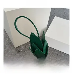 Detailed close-up of pineapple bag featuring gold rivet studs and green leaf handles