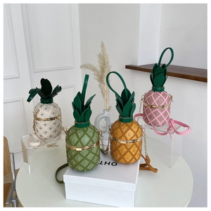 Close-up of four pineapple shaped crossbody bags with metal rivets and chain straps
