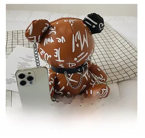 Detailed size comparison of the brown bear crossbody bag next to a smartphone