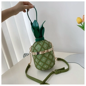 Detail of light green pineapple bag with gold studs and adjustable chain strap